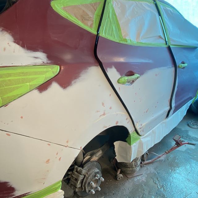 Car door in primer, masked for paint